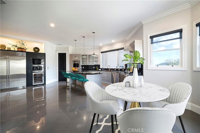 dining space with sink and ornamental molding