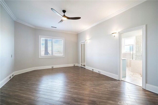 spare room featuring ceiling fan, dark hardwood / wood-style floors, a wealth of natural light, and ornamental molding