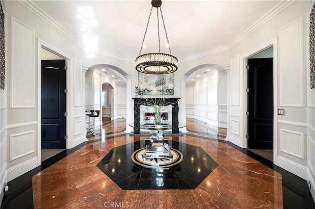 hallway with ornamental molding and a chandelier