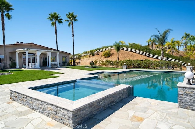 view of swimming pool with a patio area, an in ground hot tub, and a lawn