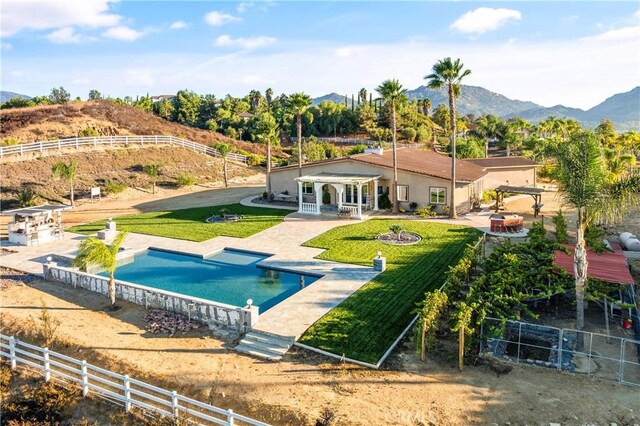 view of pool featuring a yard, a pergola, a mountain view, and a patio