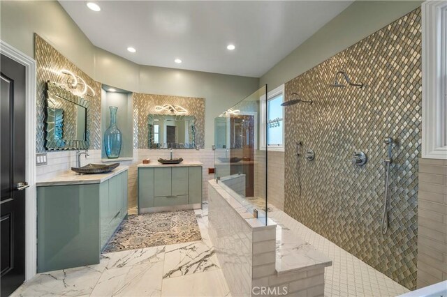 bathroom featuring tile walls, tiled shower, and vanity