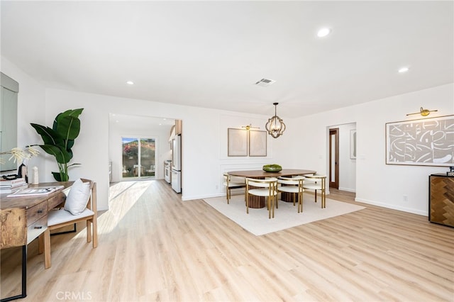 dining area featuring a chandelier and light hardwood / wood-style floors