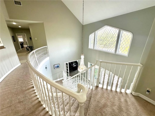 stairs with carpet, a wealth of natural light, and high vaulted ceiling