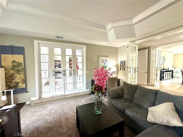 carpeted living room featuring crown molding, french doors, and a tray ceiling