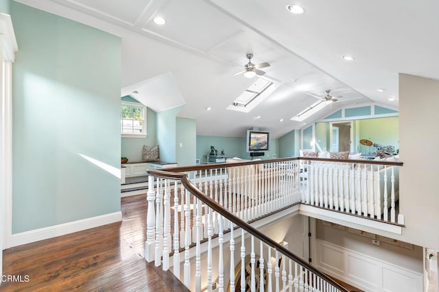 hall featuring wood-type flooring and lofted ceiling with skylight