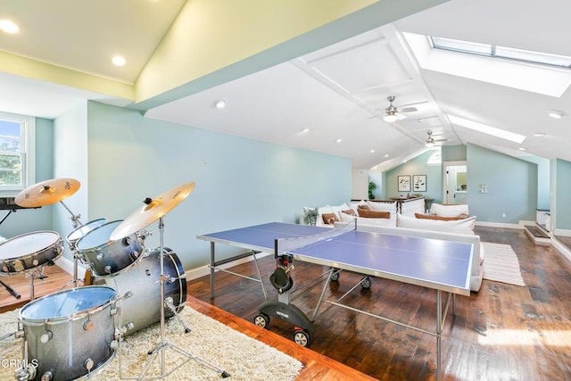 rec room with ceiling fan, wood-type flooring, and vaulted ceiling with skylight