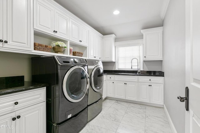 washroom with washing machine and dryer, cabinets, and sink