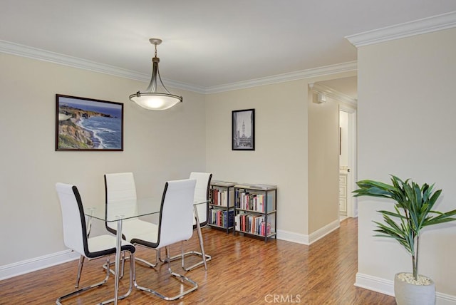 dining room with hardwood / wood-style flooring and ornamental molding