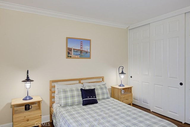 bedroom featuring a closet, dark hardwood / wood-style floors, and crown molding