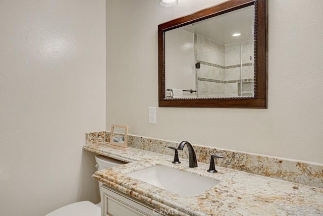 bathroom with toilet, a shower with door, and vanity