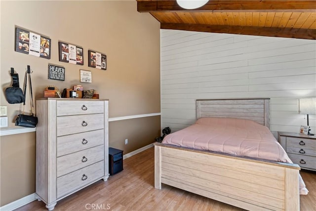 bedroom featuring vaulted ceiling with beams, light hardwood / wood-style floors, and wooden ceiling