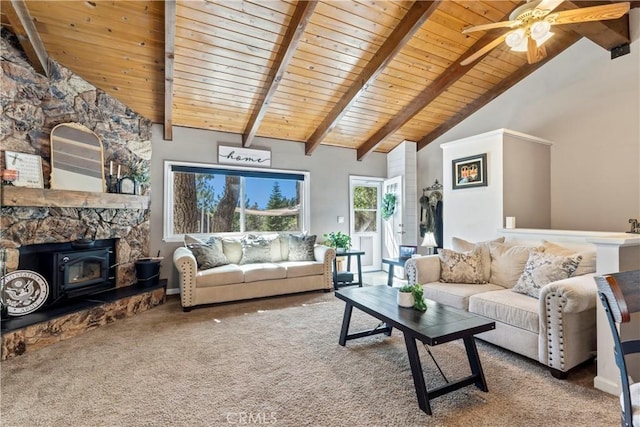 carpeted living room with wooden ceiling, ceiling fan, a wood stove, and beamed ceiling