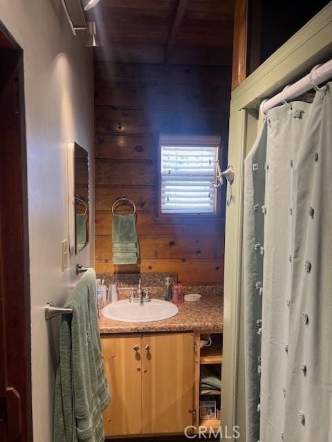 bathroom with vanity, wooden ceiling, and wooden walls