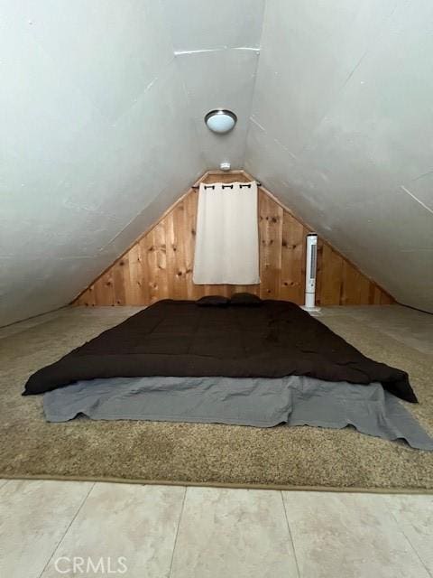 bonus room with wooden walls and vaulted ceiling