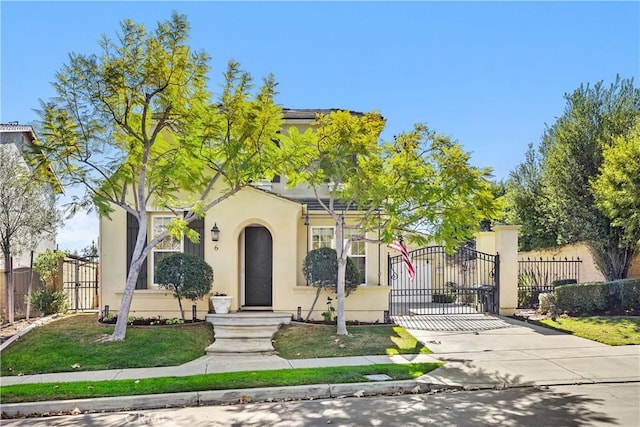 view of front of property featuring a gate, fence, concrete driveway, and stucco siding