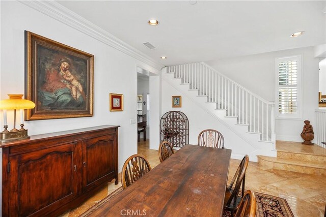 dining space featuring crown molding