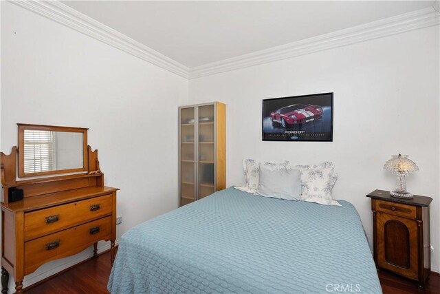 bedroom featuring dark hardwood / wood-style flooring and crown molding