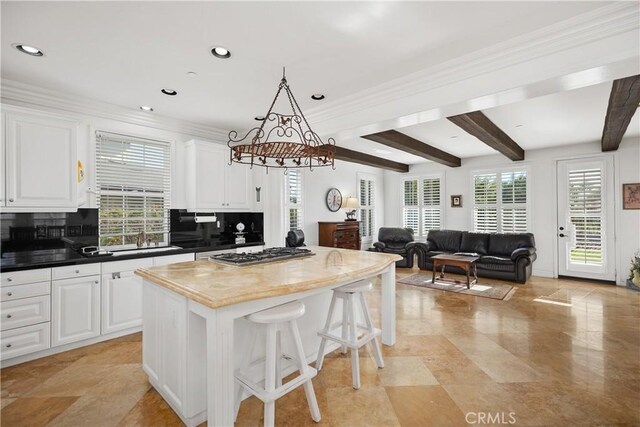 kitchen with white cabinetry, decorative backsplash, and stainless steel gas cooktop