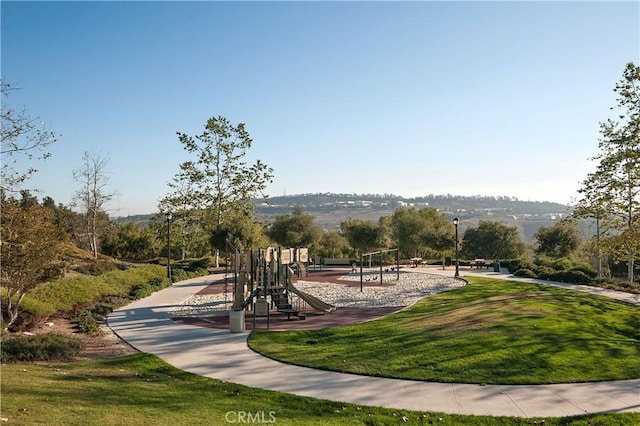 view of community featuring a playground and a lawn