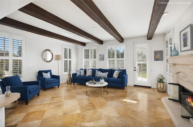 living area featuring baseboards, a high end fireplace, and beam ceiling