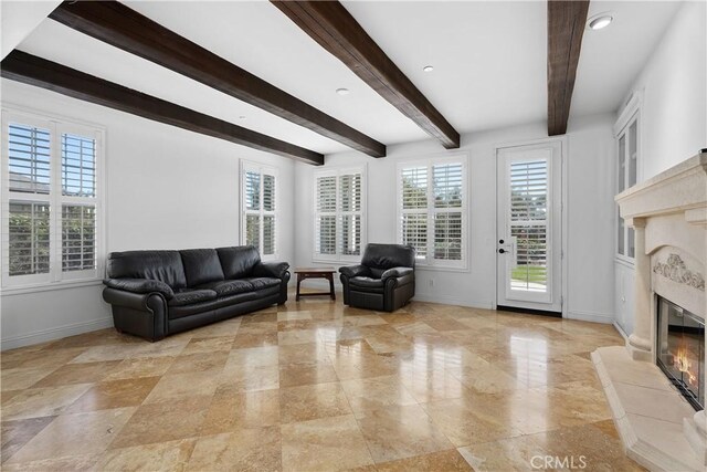 living room with beamed ceiling, recessed lighting, baseboards, and a high end fireplace