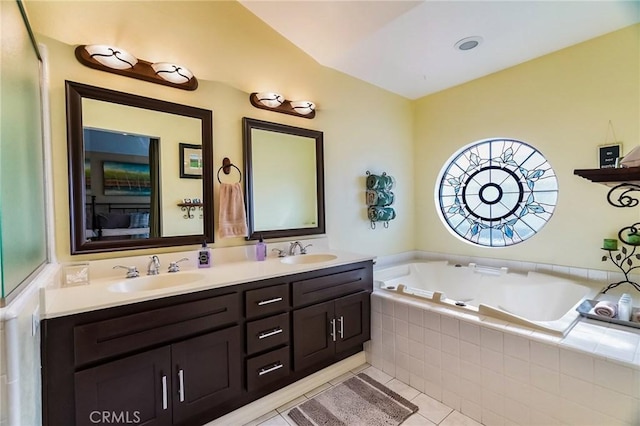 bathroom featuring tile patterned flooring, vanity, and tiled tub