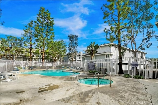 view of swimming pool with a hot tub and a patio