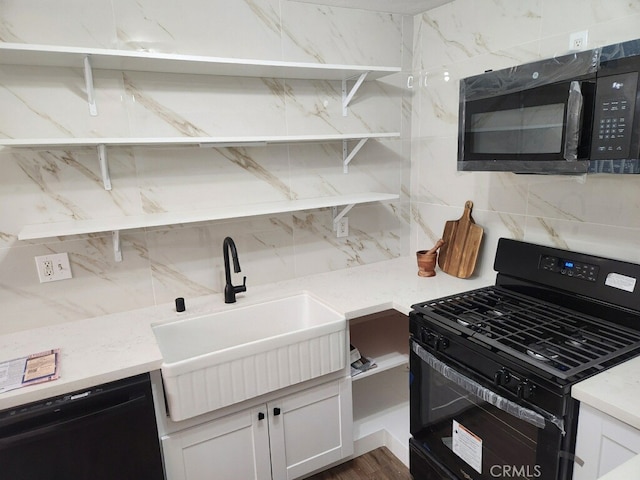 kitchen featuring decorative backsplash, sink, white cabinets, and black appliances