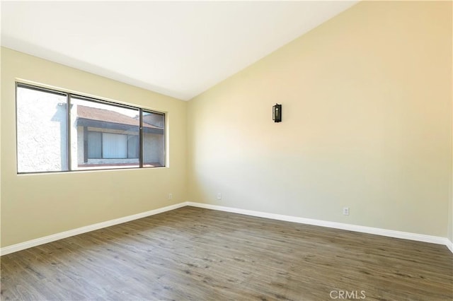 unfurnished room featuring dark wood-type flooring and lofted ceiling