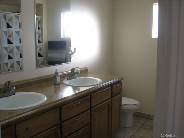 bathroom featuring toilet, vanity, and tile patterned flooring