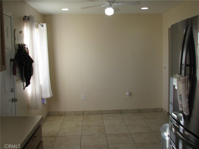 interior space with ceiling fan, light tile patterned floors, and stainless steel refrigerator