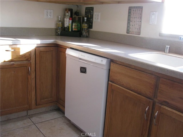 kitchen with sink, light tile patterned flooring, and white dishwasher