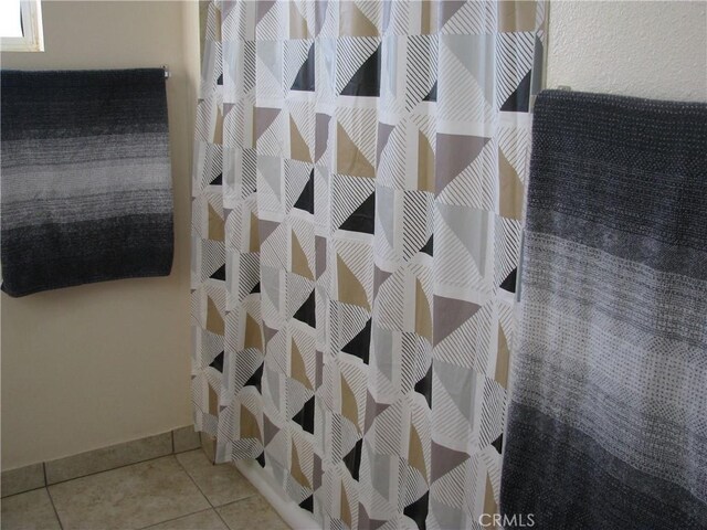 bathroom with a shower with curtain and tile patterned flooring