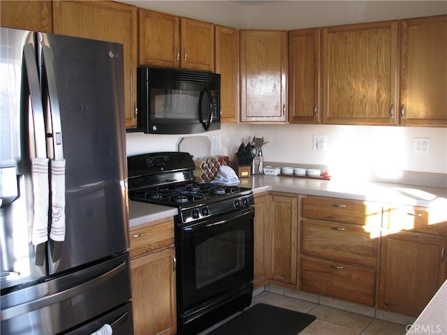 kitchen with black appliances and light tile patterned flooring