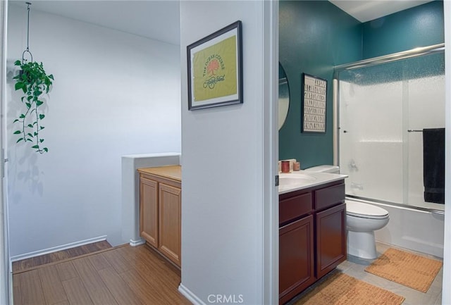 full bathroom with toilet, wood-type flooring, vanity, and shower / bath combination with glass door