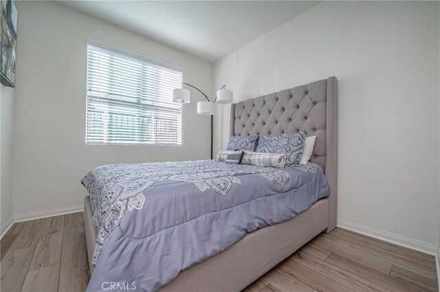 bedroom featuring light hardwood / wood-style flooring and multiple windows