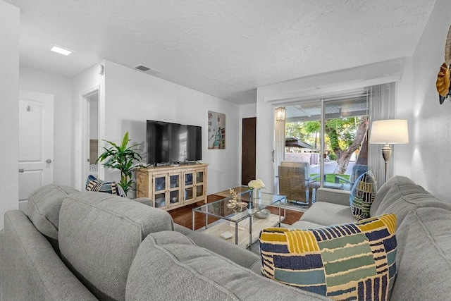 living room with hardwood / wood-style flooring and a textured ceiling