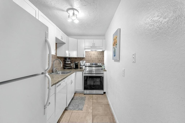 kitchen with white cabinetry, backsplash, white appliances, light tile patterned flooring, and sink