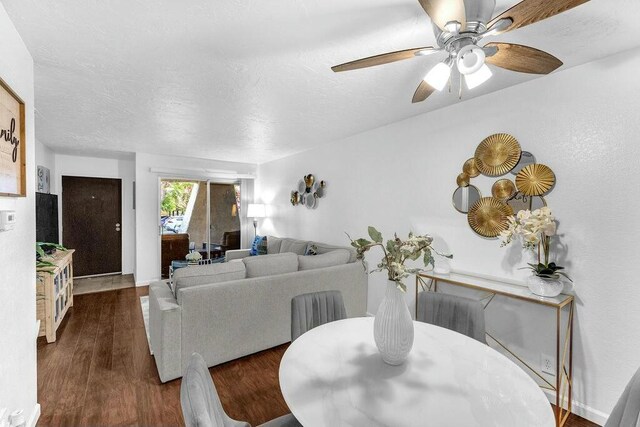 living room with ceiling fan and dark hardwood / wood-style floors