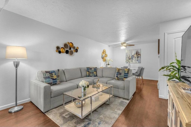 living room with ceiling fan, a textured ceiling, and hardwood / wood-style floors