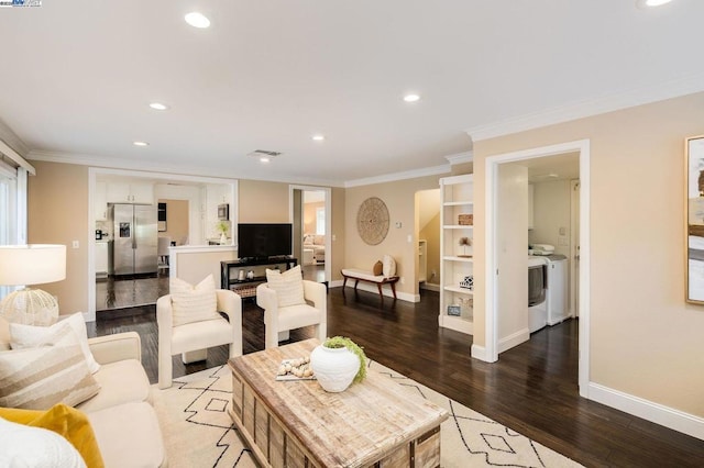 living room featuring independent washer and dryer, ornamental molding, and hardwood / wood-style floors