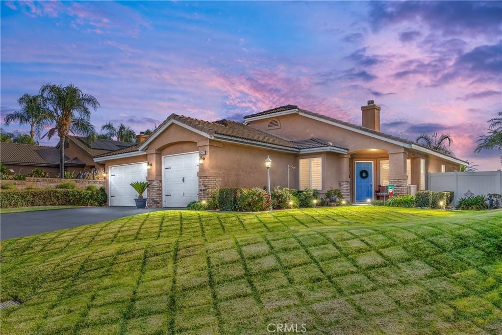 view of front of property with a garage and a lawn