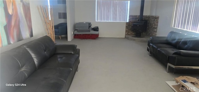 carpeted living room with a wood stove