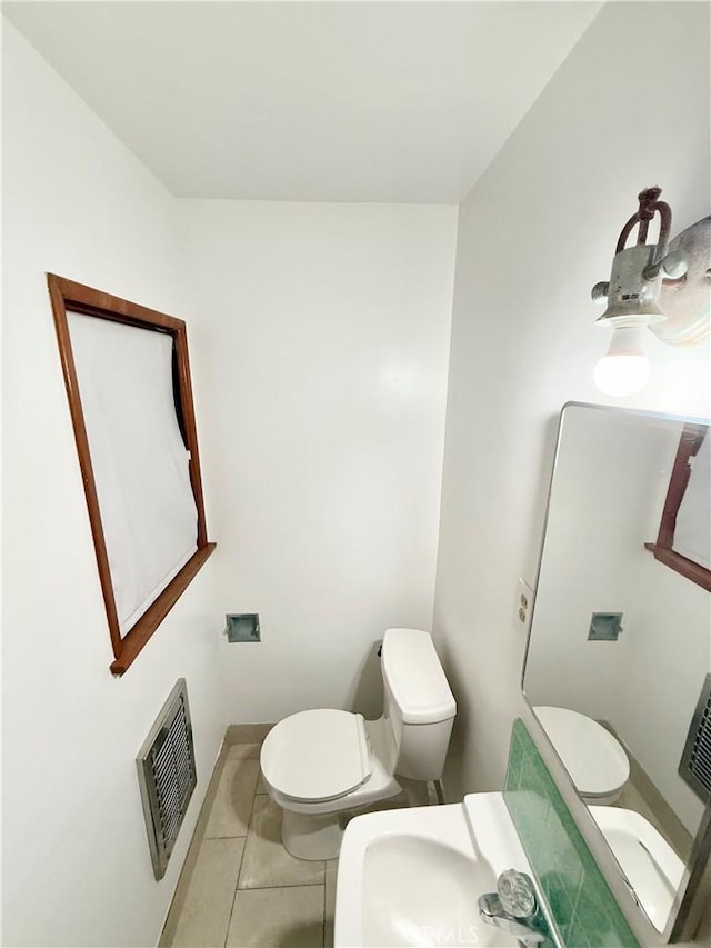 bathroom featuring heating unit, tile patterned flooring, and toilet