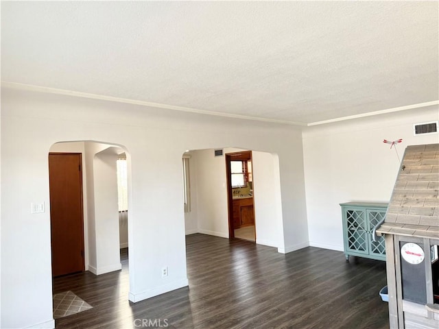 unfurnished living room featuring dark wood-type flooring and a textured ceiling