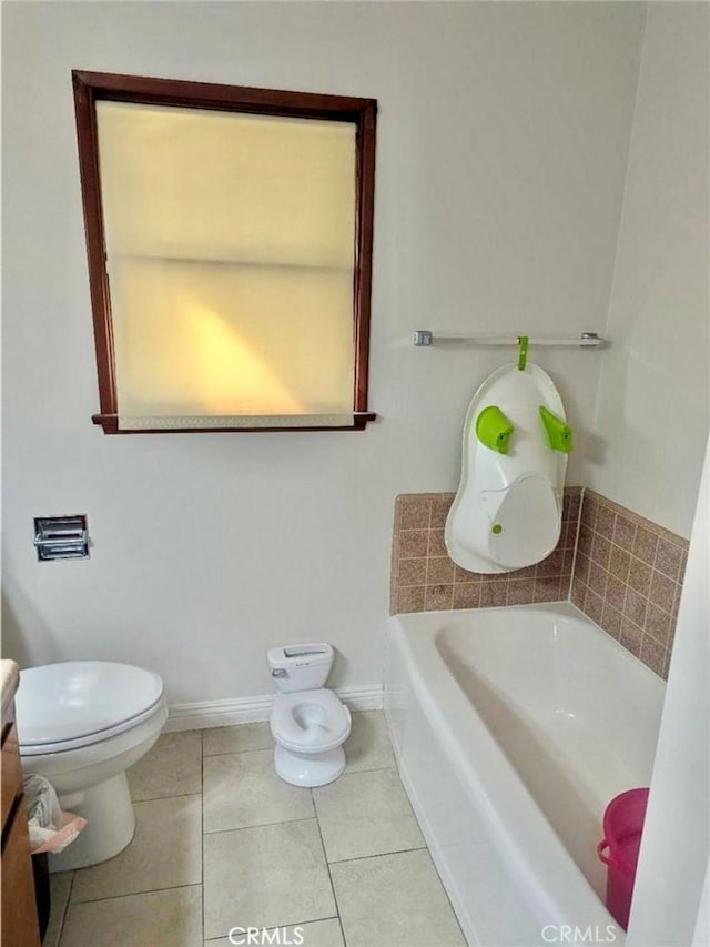 bathroom with tile patterned flooring, vanity, a bath, and toilet