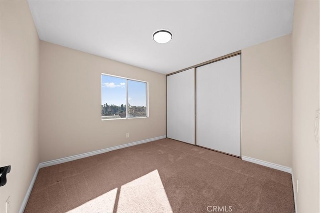 unfurnished bedroom featuring a closet and carpet flooring