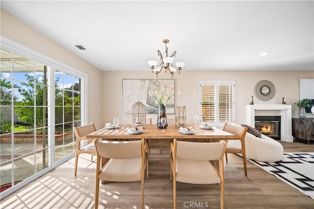 dining space featuring wood-type flooring and a notable chandelier