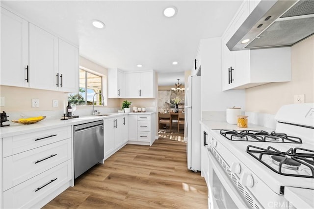 kitchen with range hood, sink, white appliances, light wood-type flooring, and white cabinets